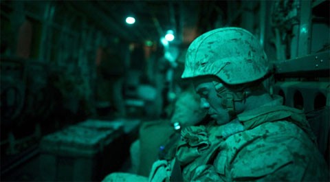 Một lính thủy đánh bộ của Tiểu đoàn số 1, Binh đoàn lính thủy đánh bộ số 8, tranh thủ chợp mắt trên một chiếc trực thăng đang bay tới căn cứ quân sự ở huyện Musa Qala, thuộc tỉnh miền tây nam Helmand của Afghanistan, vào sáng sớm ngày 16/1. Tổng thống Mỹ Barack Obama hồi tháng 6 tuyên bố kế hoạch rút 33.000 lĩnh Mỹ khỏi Afghanistan từ nay tới sau mùa hè năm 2012, và sẽ rút toàn bộ vào cuối năm 2014. Ảnh: AFP